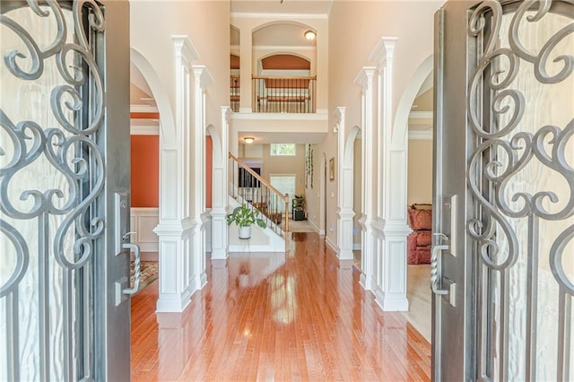 3202 Lucky Pl, Conyers, GA 30013 - foyer entrance featuring a high ceiling, light wood-style flooring, arched walkways, stairs, and ornamental molding