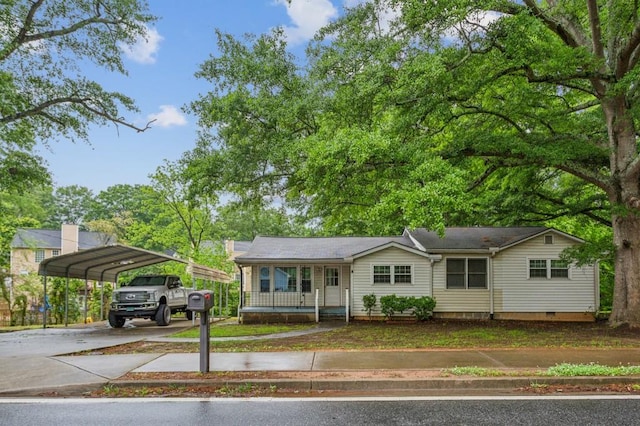 view of front of property with concrete driveway, a detached carport, crawl space, and covered porch