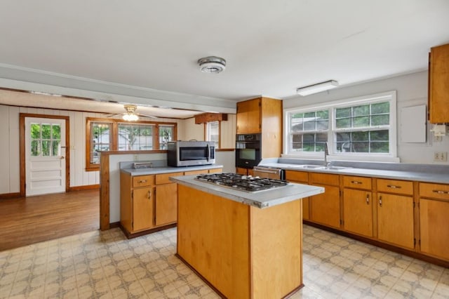 kitchen featuring light flooring, stainless steel appliances, a sink, and light countertops