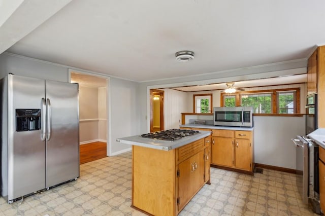 kitchen featuring stainless steel appliances, light flooring, light countertops, baseboards, and crown molding