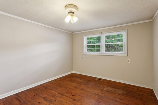unfurnished room with baseboards, crown molding, and hardwood / wood-style floors