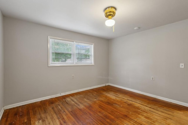 unfurnished room with hardwood / wood-style flooring, baseboards, and a smoke detector