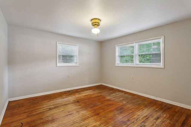 empty room with baseboards and hardwood / wood-style floors
