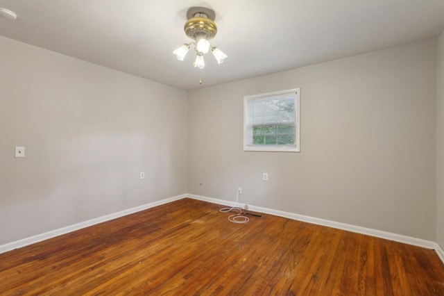 empty room with baseboards, wood finished floors, and a ceiling fan