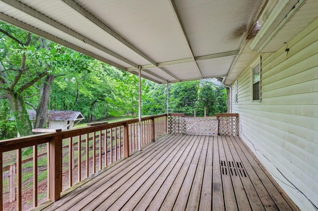 wooden terrace featuring view of wooded area