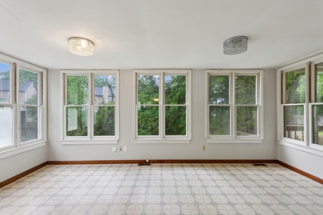 unfurnished sunroom featuring baseboards