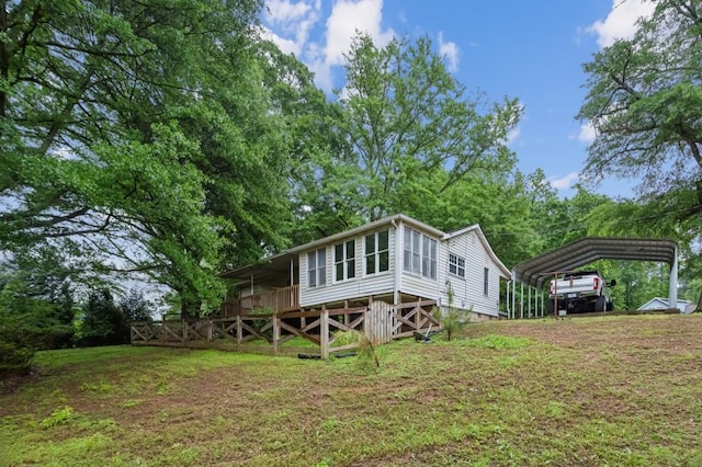 rear view of house with a carport and a yard