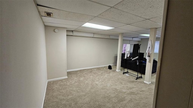 finished basement with carpet, a drop ceiling, visible vents, and baseboards