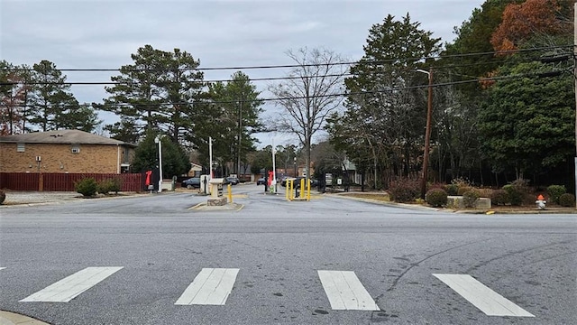 view of street with street lighting, curbs, and a gated entry