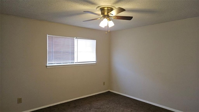 spare room with dark carpet, a textured ceiling, baseboards, and ceiling fan