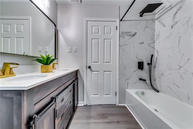 full bath featuring double vanity, washtub / shower combination, a sink, and wood finished floors