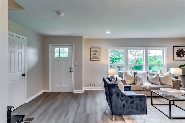 living room featuring recessed lighting, baseboards, visible vents, and wood finished floors