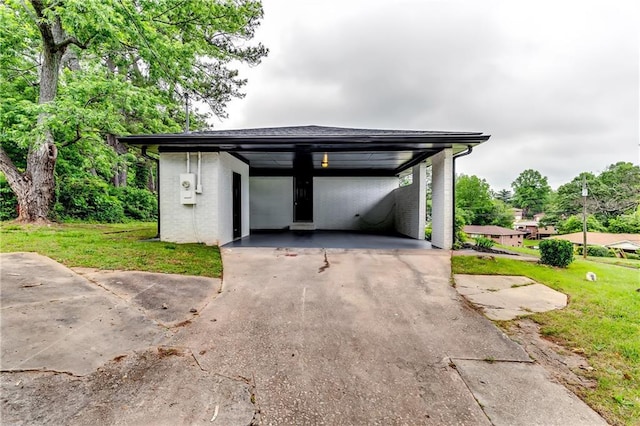 view of front facade with brick siding, driveway, a carport, and a front lawn