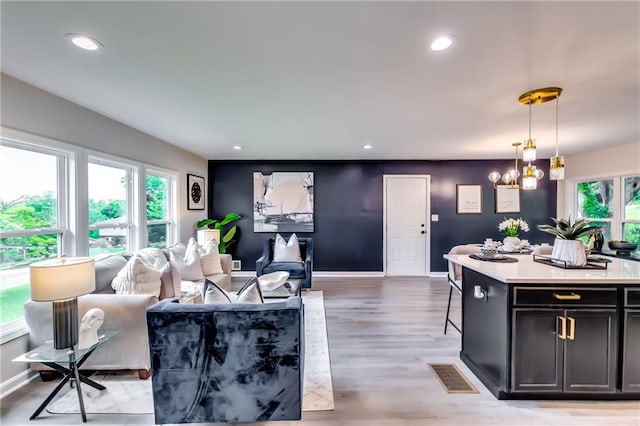 living room featuring recessed lighting, visible vents, light wood-type flooring, and a chandelier