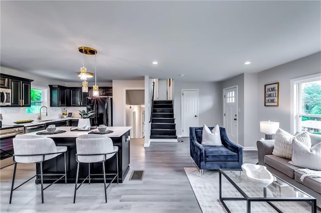 kitchen with open floor plan, appliances with stainless steel finishes, a sink, and visible vents