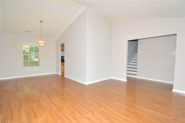 2172 Cold Springs Cir, Lithonia, GA 30058 - spare room featuring a chandelier, vaulted ceiling, light wood-style flooring, stairs, and crown molding