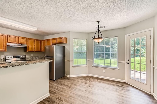 230 Belmont Trl, Covington, GA 30016 - kitchen with appliances with stainless steel finishes, under cabinet range hood, brown cabinetry, light wood-type flooring, and a textured ceiling