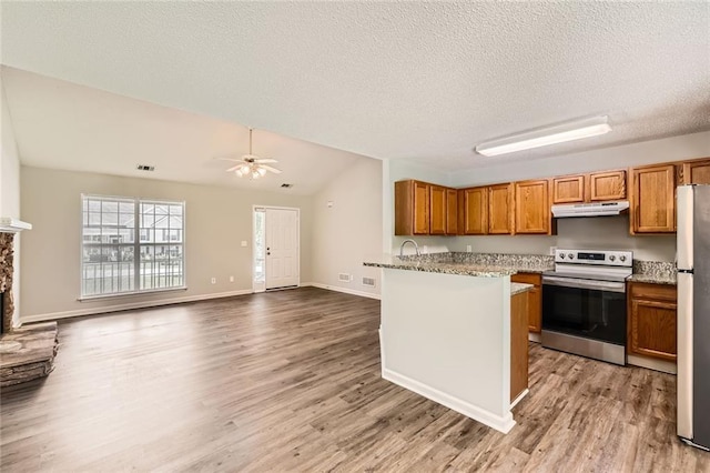 230 Belmont Trl, Covington, GA 30016 - kitchen featuring appliances with stainless steel finishes, under cabinet range hood, brown cabinets, light wood finished floors, and a textured ceiling