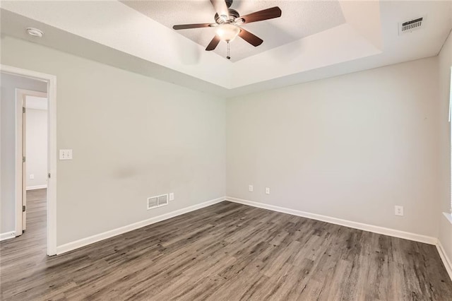 230 Belmont Trl, Covington, GA 30016 - spare room featuring a tray ceiling, wood finished floors, a ceiling fan, and a smoke detector