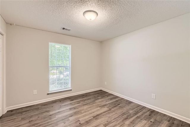 230 Belmont Trl, Covington, GA 30016 - empty room with wood finished floors and a textured ceiling