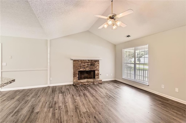 230 Belmont Trl, Covington, GA 30016 - unfurnished living room with ceiling fan, lofted ceiling, dark wood finished floors, a stone fireplace, and a textured ceiling