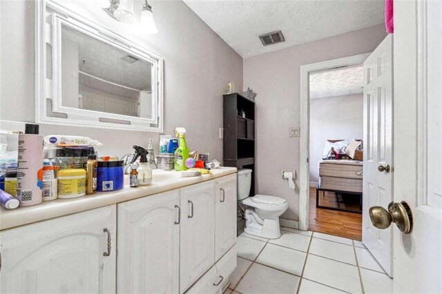 270 Oak Ridge Rd, Covington, GA 30016 - ensuite bathroom featuring vanity, toilet, a textured ceiling, tile patterned floors, and visible vents