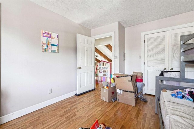 270 Oak Ridge Rd, Covington, GA 30016 - bedroom with baseboards, a textured ceiling, light wood-style floors, and a closet