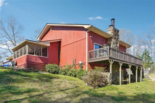 270 Oak Ridge Rd, Covington, GA 30016 - view of side of property featuring a sunroom, a deck, a yard, and a chimney