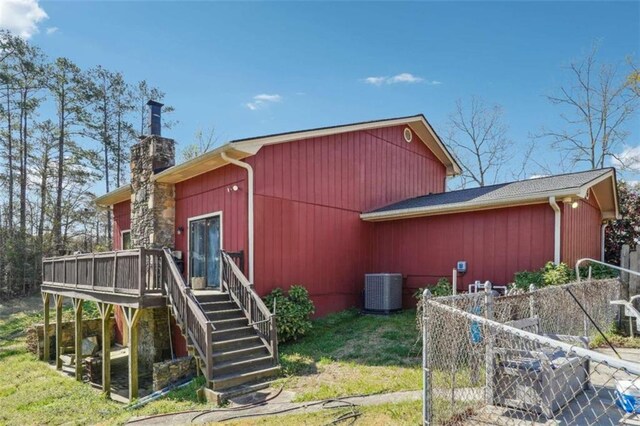 270 Oak Ridge Rd, Covington, GA 30016 - exterior space with central AC unit, a wooden deck, a chimney, stairs, and a yard