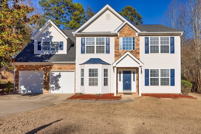 view of front of home with driveway, roof with shingles, and an attached garage