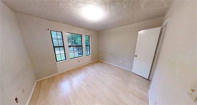 empty room featuring light hardwood / wood-style flooring and a textured ceiling