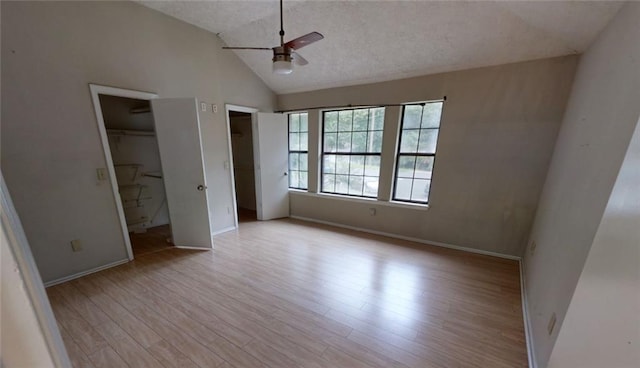 unfurnished bedroom with light hardwood / wood-style floors, lofted ceiling, a textured ceiling, and ceiling fan