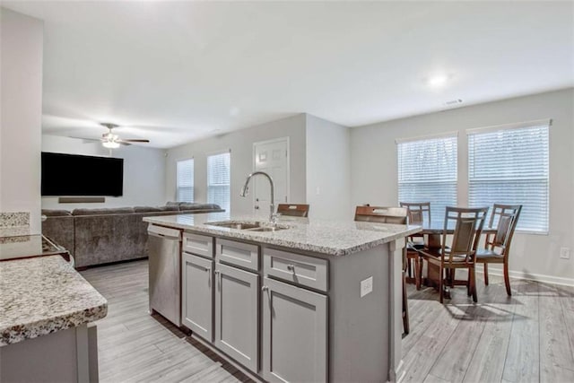 kitchen with ceiling fan, dishwasher, gray cabinets, light wood-style floors, and a sink