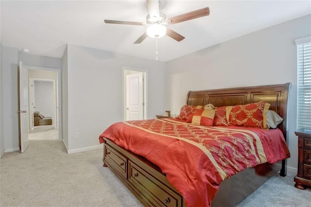 bedroom featuring light colored carpet, baseboards, and ceiling fan