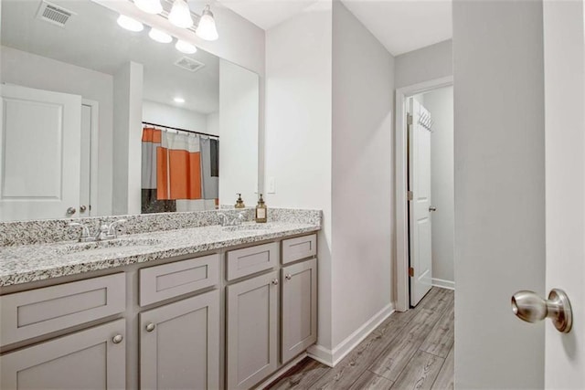 bathroom featuring a sink, visible vents, and wood finished floors