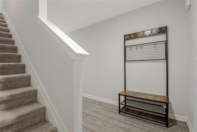 stairway with wood finished floors and baseboards