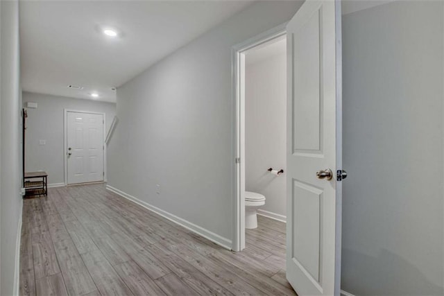 corridor with baseboards and light wood-type flooring