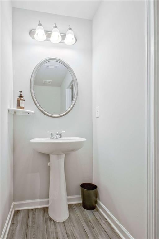 bathroom with wood finished floors and baseboards