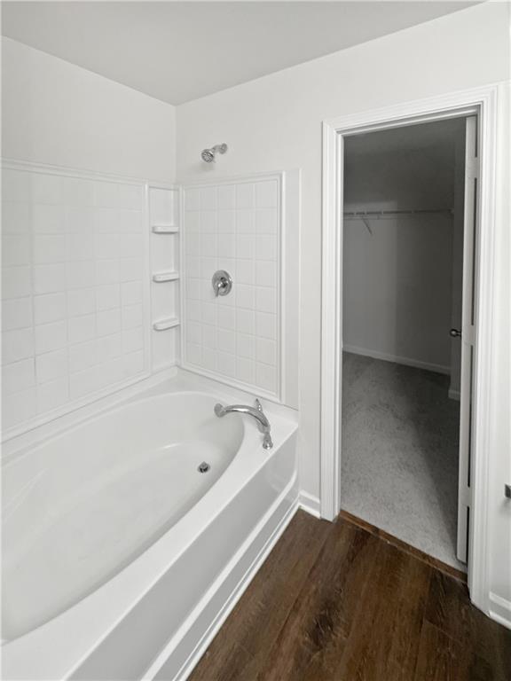 bathroom with wood-type flooring and tub / shower combination