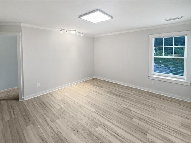 spare room with crown molding and light hardwood / wood-style floors