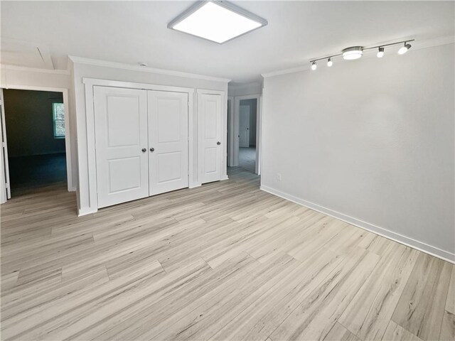 interior space featuring ornamental molding, light hardwood / wood-style flooring, and a closet