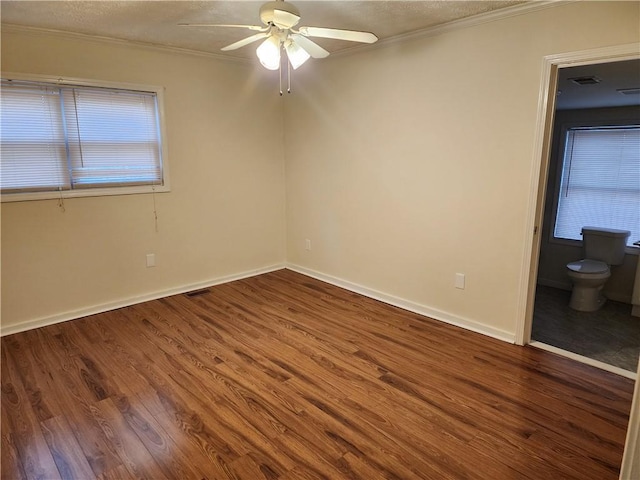 unfurnished bedroom featuring crown molding, visible vents, baseboards, and wood finished floors