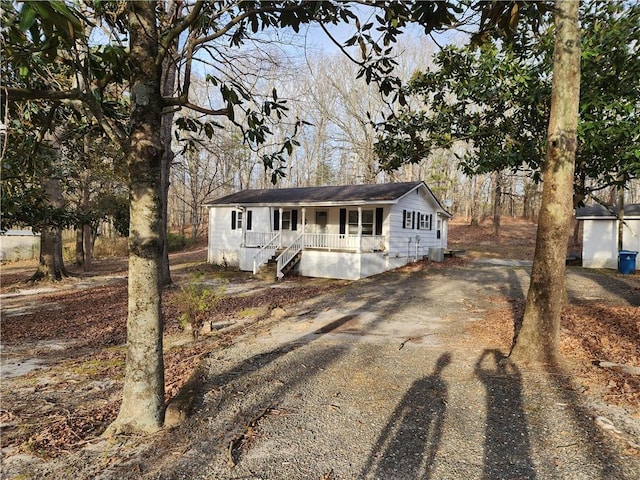 view of front of home featuring a porch and dirt driveway