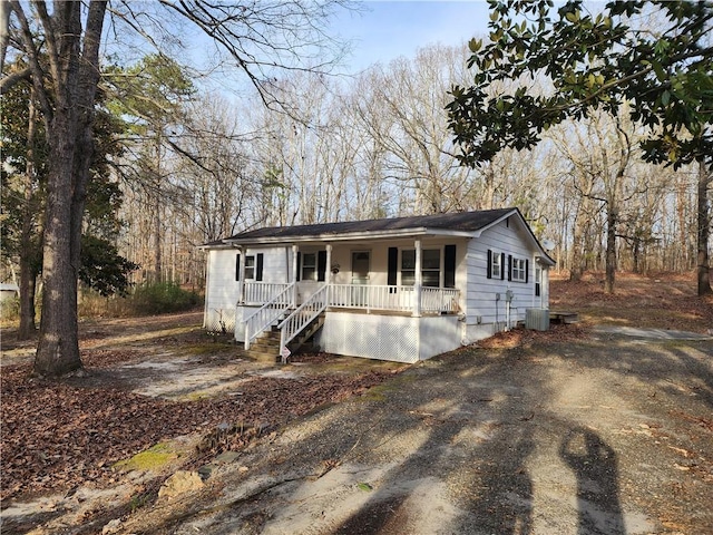 view of front facade with driveway, covered porch, and cooling unit