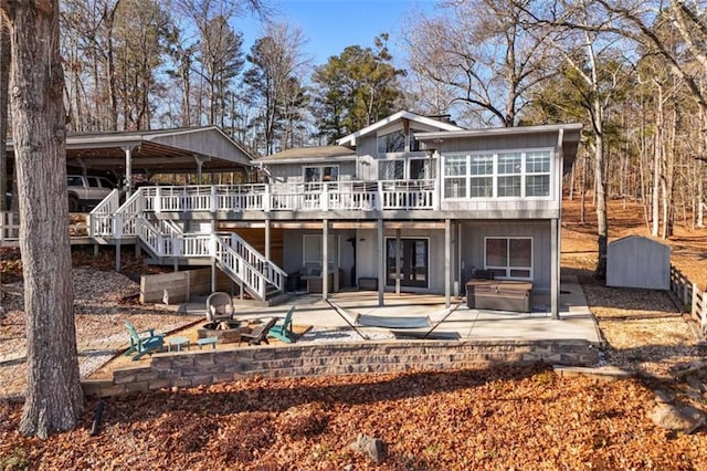 rear view of house featuring a patio, a deck, and a fire pit