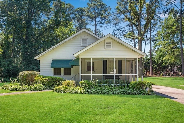 bungalow-style home with a front lawn and a sunroom