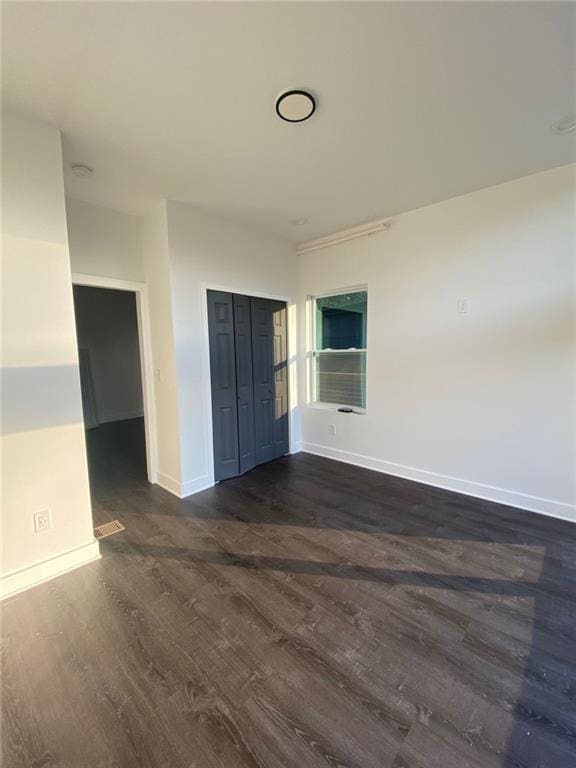 spare room featuring dark wood-type flooring