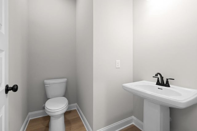 bathroom with sink, toilet, and hardwood / wood-style floors