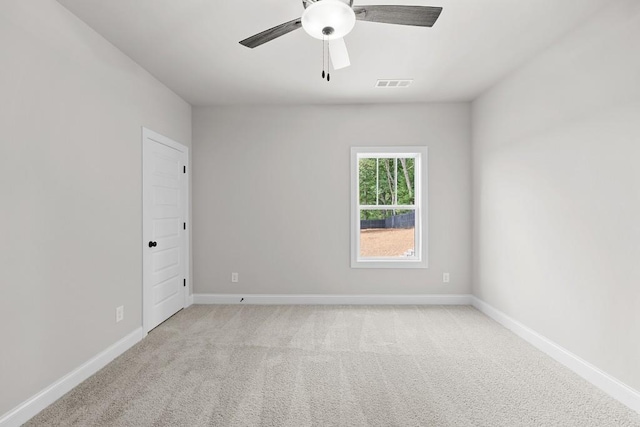 spare room with ceiling fan and light colored carpet