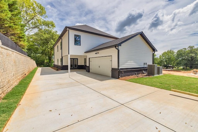 view of side of home with a garage and a lawn